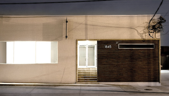 A night image of a one-story gallery building.