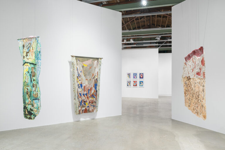 Three suspended abstract works by Suzanne Jackson hang in a gallery.