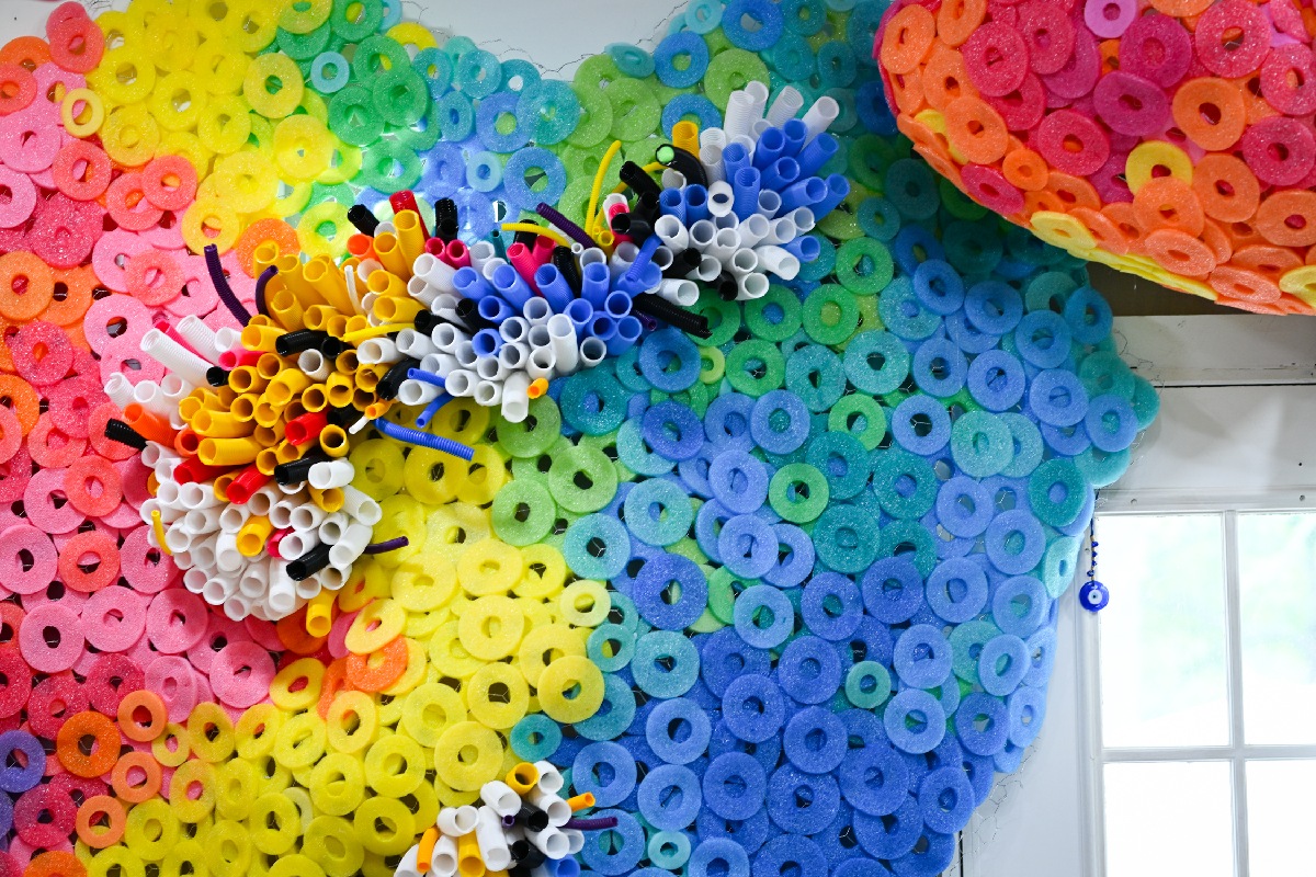 A collection of large sculptures covered in circular discs that are multicolor.